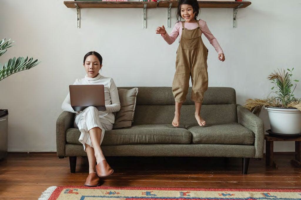 a working mother and daughter on the sofa