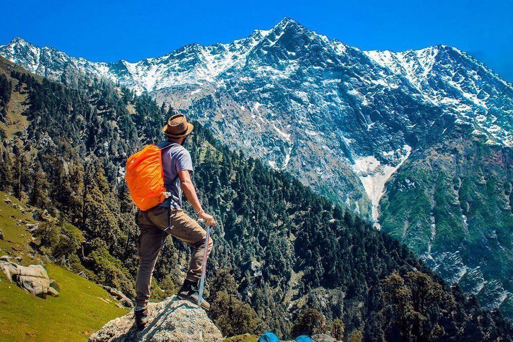 A traveller with a backpack looking out over a landscape.