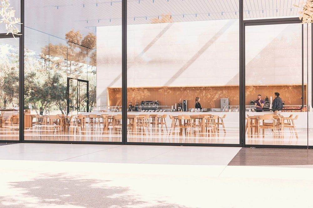 An office cafe finished in timber with daylight from full-height glazing/