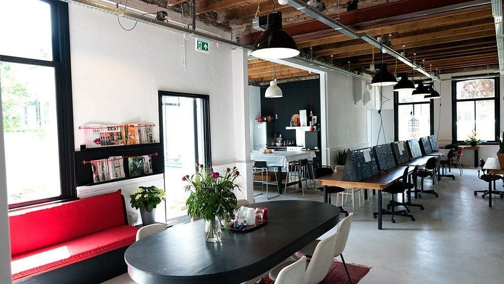 An open-plan office floor with shared desks and few dividing barriers